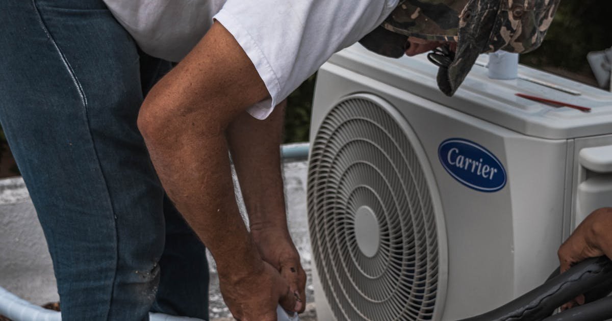 HVAC technician servicing an outdoor air conditioning unit